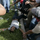 Varios manifestantes contemplan el cadáver de uno de los jóvenes fallecidos.