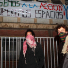 Dos miembros del colectivo muestran una pancarta en el Laboratorio Pecuario.