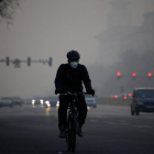 Un ciclista circula por Pekín en un día de alta contaminación.