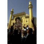 Seguidores de Al Sáder portan su imagen frente a la mezquita de Nayaf