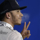 Lewis Hamilton hace el signo de la victoria tras conseguir la 'pole' del GP de Baréin.