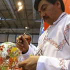 Un mexicano pinta un jarrón en el stand de su país montado en la XXIX edición de Fitur