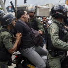 Imagen de archivo de miembros de la Guardia Nacional Bolivariana de Venezuela, detieneniendo a un joven en 2012.