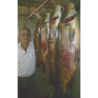 Ángel Fuentes posa orgulloso con las carpas recién pescadas.