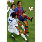 Ronaldinho controla un balón ante la mirada de los jugadores coreanos