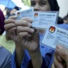 Un grupo de indonesas muestran sus carnés para votar