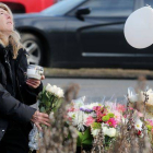 Una mujer deposita flores en el lugar del homenaje a las víctimas de la matanza.