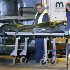Funcionarios del retén fúnebre trasladan a la fallecida.
