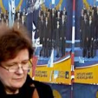 Una mujer pasa ante uno de los carteles electorales en Belgrado