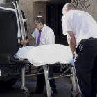 Los servicios funerarios trasladan el cuerpo de la mujer de 36 anos que ha sido hallada muerta esta tarde en su domicilio de Alcorcon con dos heridas de arma blanca una en el cuello y otra en el pecho.
