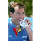 David Meca se muestra sonriente mordiendo la medalla conseguida