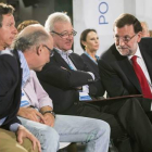 Rajoy habla con Cristóbal Montoro ante el presidente del PP de Murcia, Ramón Luis Valcárcel, y Carlos Floriano, durante la Intermunicipal del PP, este domingo en Murcia