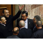 Panagiotis Iliopoulos, diputado del partido ultraderechista griego Amanecer Dorado, abandona el pleno del Parlamento acompañado por miembros de su partido tras ser expulsado por su comportamiento.