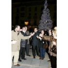 Mario Amilivia, en el centro, brinda por unas felices fiestas con el árbol iluminado detrás