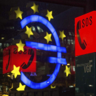 El símbolo del Euro reflejado al letrero de un teléfono de emergencia, en Fráncfort. BORIS ROESSLER