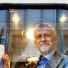 Jeremy Corbyn fotografiado en el interior de un vagón de tren sujetando dos billetes.