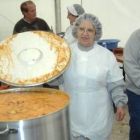 Una cocinera de la feria de Chozas del año pasado muestra una cazuela gigante con un guiso de patata