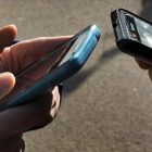 Dos jóvenes intercambiando información con sus teléfonos móviles.