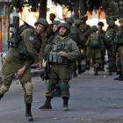 Un soldado israelí lanza un petardo contra un grupo de palestinos en Hebron durante un enfrentamiento, el pasado 13 de octubre.