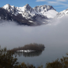 La niebla se aferra a la lámina de agua del embalse, pero permite ver las cimas de la montaña de Riaño. RAMIRO