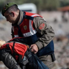 Un policía turco traslada el cuerpo sin vida de un niño tras otro naufragio en el Egeo.