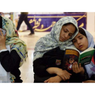 Varias mujeres iraníes visitan la Feria del Libro de Teherán que se celebra en la mezquita del imán Jomeini, en Teherán. Abajo, Varios iraníes queman la bandera nacional estadounidense durante una manifestación.