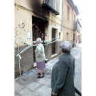 Dos vecinas pasan ante la vivienda afectada por el incendio de ayer