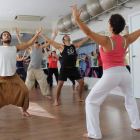 El grupo de participantes realizan una serie de movimientos y posturas yóguicas con la profesora Mataji.