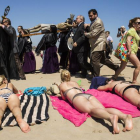 Bañistas y cofrades, en la playa de la Malvarrosa de Valencia, en la Semana Santa del 2014.