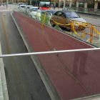 Un hombre observa la barandilla de cristal rota en uno de los accesos al centro comercial.