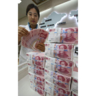 Una oficinista cuenta billetes de 100 yuanes chinos.