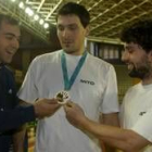 Colón, a la izquierda, toca la medalla de campeón olímpico de Petar