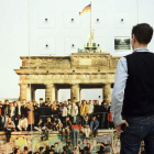 Un hombre ante una imagen interactiva de la caída del muro. Derecha, Una instalación que permanece sin las cruces blancas que fueron colocadas en memoria de las víctimas que perdieron la vida en el muro de Berlín