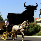 Un toro de la firma Osborne instalado en la sevillana glorieta del Cid, con una típica calesa en primer término.