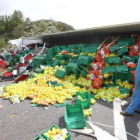 La carga de naranjas y hortalizas quedó esparcida sobre el asfalto con el camión volcado.
