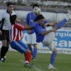 Jugadores disputando el balón ante la mirada del árbitro