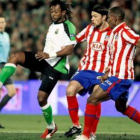 El delantero del Racing Tchité controla el balón ante los defensas del Atlético de Madrid.