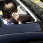 Un joven habla por teléfono mientras conduce.