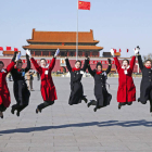 Un grupo de administrativas salta para una foto de recuerdo en la plaza de Tiananmen.