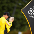 Chris Froome, el ciclista británico, sostiene en brazos a Kellan, su hijo, en el podio de París.