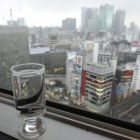 Un vaso de agua, junto a una ventana en un restaurante del centro de Tokio.