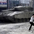 Un joven palestino lanza una piedra a un tanque israelí en la localidad de Jenin