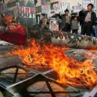 Un grupo de personas quema retratos del líder norcoreano, Kim Jong-Il