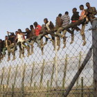 Imagen de un grupo de migrantes subidos a la valla de Melilla. FRANCISCO G. GUERRERO