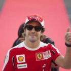 Fernando Alonso saluda a sus aficionados sobre la alfombra roja de Suzuka.