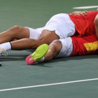Rafa Nadal y Marc López se abrazan en el suelo tras clasificarse para la final olímpica.