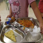 Una niña recoge su bandeja en un comedor escolar.