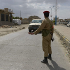 Un soldado obliga a la detención de un vehículo en un puesto de control en Yemen.