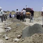 Un grupo de iraquíes camina sobre las ruinas de la casa en Faluya
