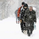 Vecinos de Reinosa, en Cantabria, caminan entre la copiosa nieve.